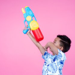 Super soaker cruises on Ripon Canal image of little boy on pink background with waterpistol toy